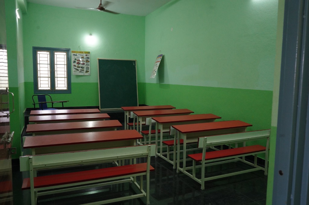 Vikas School Senior Classroom with red bench-desks and blackboard